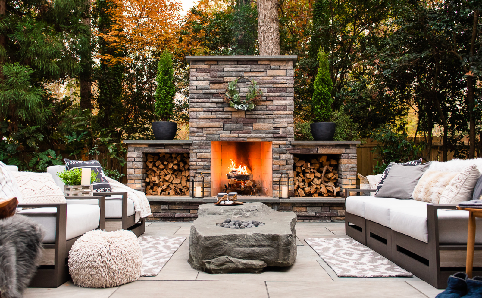 Large outdoor stone fireplace with log storage and seating