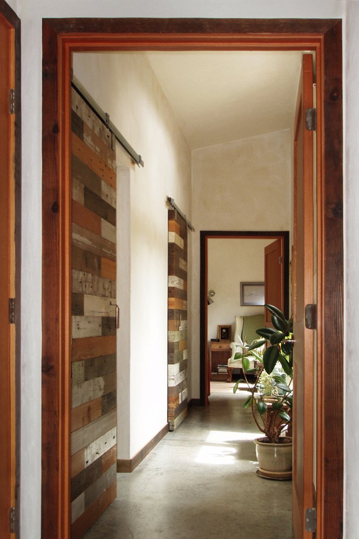 Reclaimed wood sliding barn door with lime plaster hallway